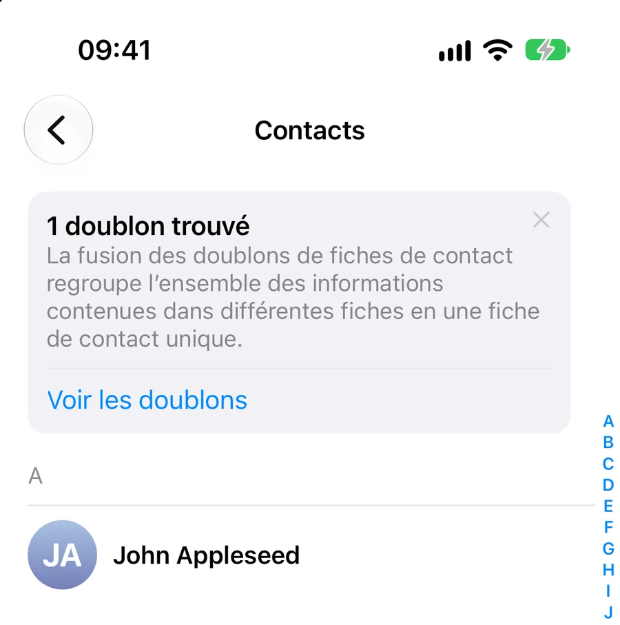 La liste Contacts. En haut, un encadré intitulé « 1 doublon trouvé » explique que la fusion regroupe les informations de plusieurs fiches en une fiche unique, et propose un lien Voir les doublons. En dessous commence la liste, avec John Appleseed sous la lettre A.