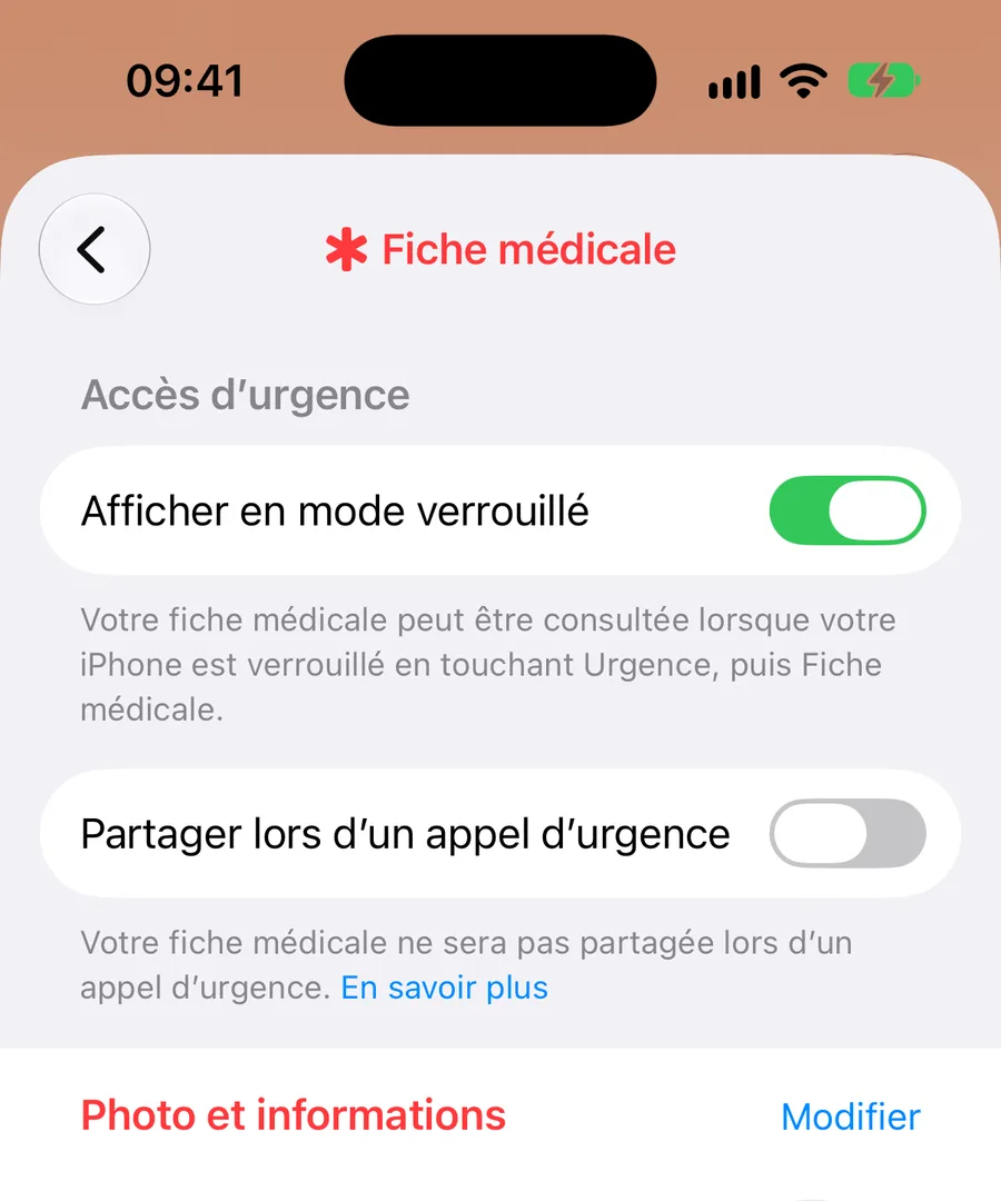 Haut de la Fiche médicale, dans l'app Santé. Rubrique Accès d'urgence : l'interrupteur Afficher en mode verrouillé est activé, avec l'explication « Votre fiche médicale peut être consultée lorsque votre iPhone est verrouillé en touchant Urgence, puis Fiche médicale. » En dessous, l'interrupteur Partager lors d'un appel d'urgence, désactivé. Plus bas commence la rubrique Photo et informations, avec son bouton Modifier.
